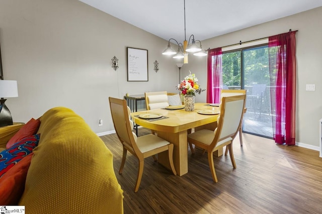 dining area featuring vaulted ceiling, hardwood / wood-style floors, and a notable chandelier