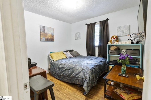 bedroom with hardwood / wood-style floors and a textured ceiling