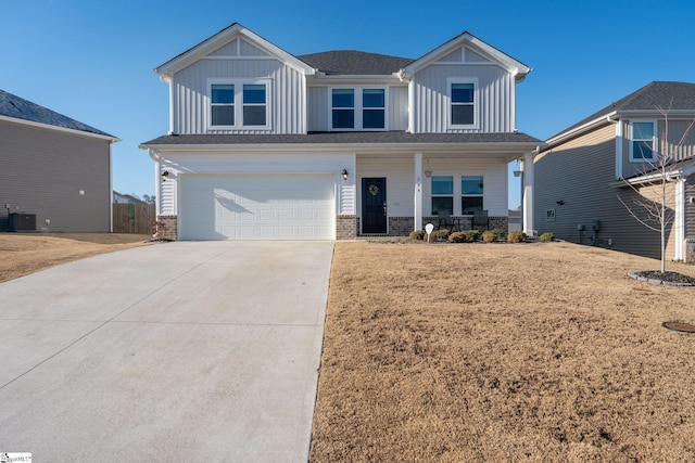 view of front of property featuring a garage, covered porch, a front yard, and central air condition unit