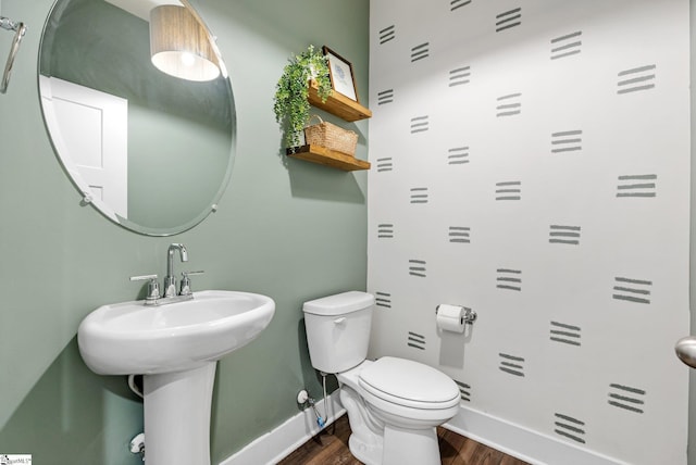 bathroom with wood-type flooring, sink, and toilet