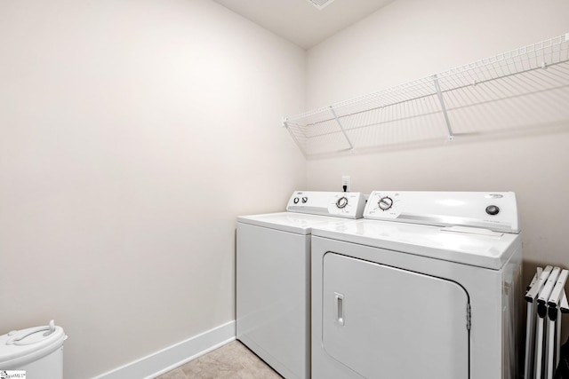 washroom featuring washing machine and clothes dryer and light tile patterned flooring