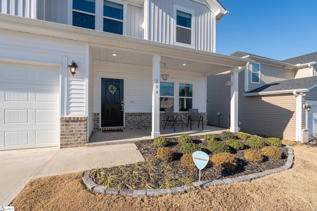 doorway to property featuring a garage and covered porch