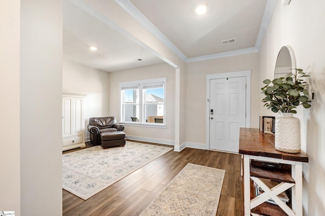 foyer entrance featuring crown molding and dark hardwood / wood-style flooring