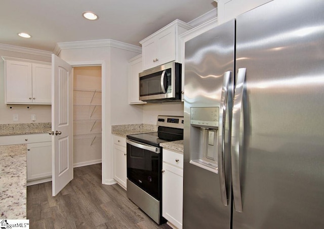 kitchen with white cabinetry, stainless steel appliances, and light stone countertops