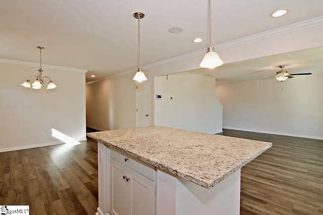 kitchen with a center island, white cabinets, dark hardwood / wood-style flooring, and decorative light fixtures