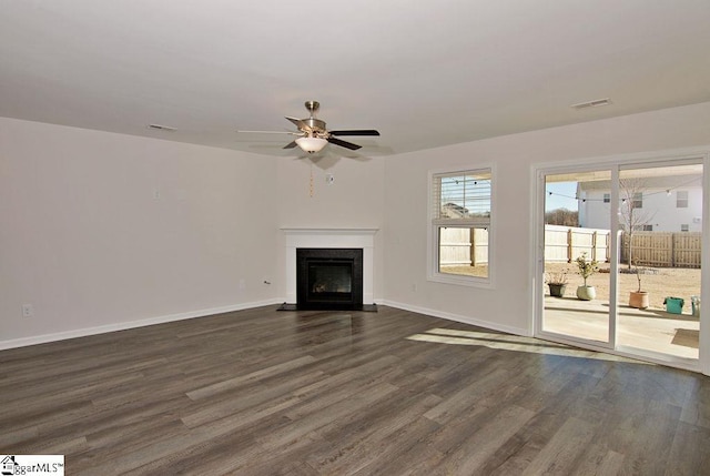 unfurnished living room featuring dark wood-type flooring and ceiling fan