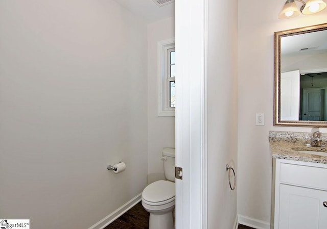 bathroom with hardwood / wood-style flooring, vanity, and toilet