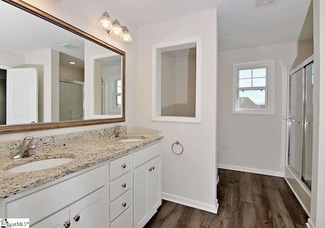 bathroom featuring hardwood / wood-style flooring, vanity, and a shower with shower door