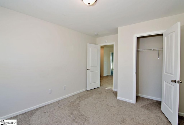 unfurnished bedroom with light carpet and a closet