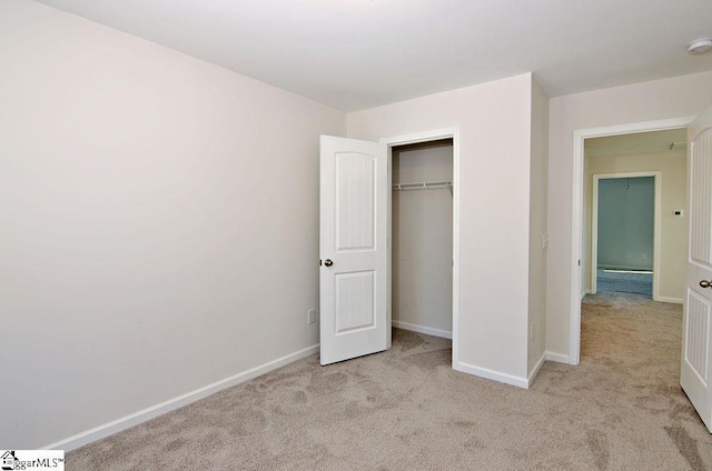 unfurnished bedroom featuring light colored carpet and a closet