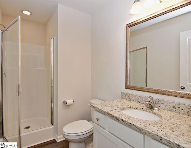 bathroom featuring vanity, toilet, and walk in shower