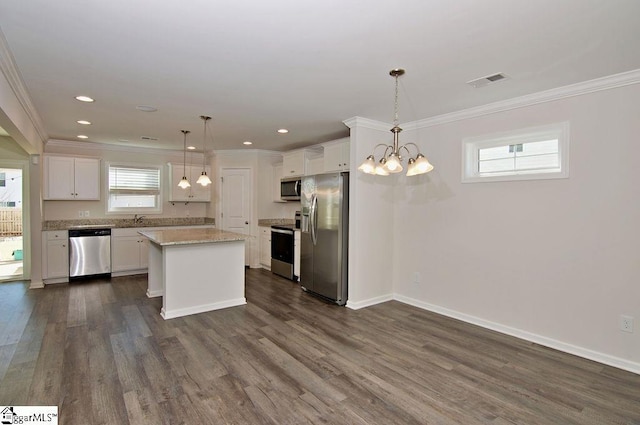 kitchen featuring appliances with stainless steel finishes, a center island, hanging light fixtures, and white cabinets