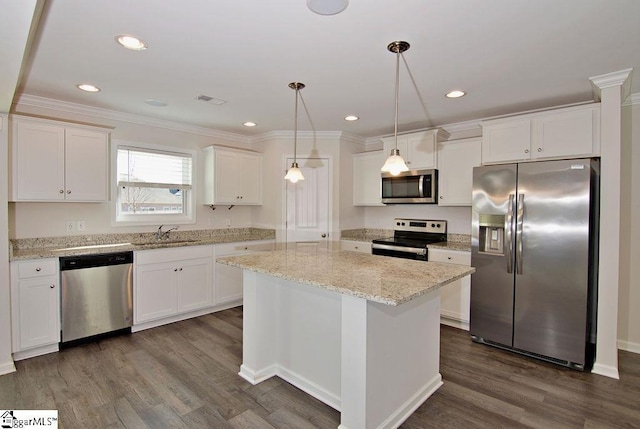 kitchen featuring white cabinetry, stainless steel appliances, a kitchen island, and hanging light fixtures