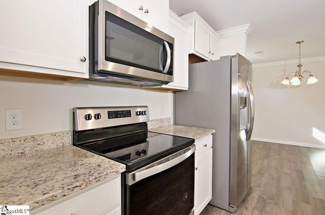 kitchen with light hardwood / wood-style flooring, appliances with stainless steel finishes, light stone counters, ornamental molding, and white cabinets