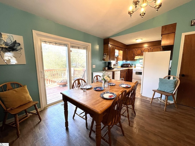 dining area featuring lofted ceiling, dark wood-type flooring, sink, and a chandelier