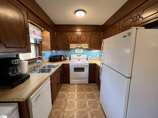 kitchen featuring sink, white appliances, and a textured ceiling