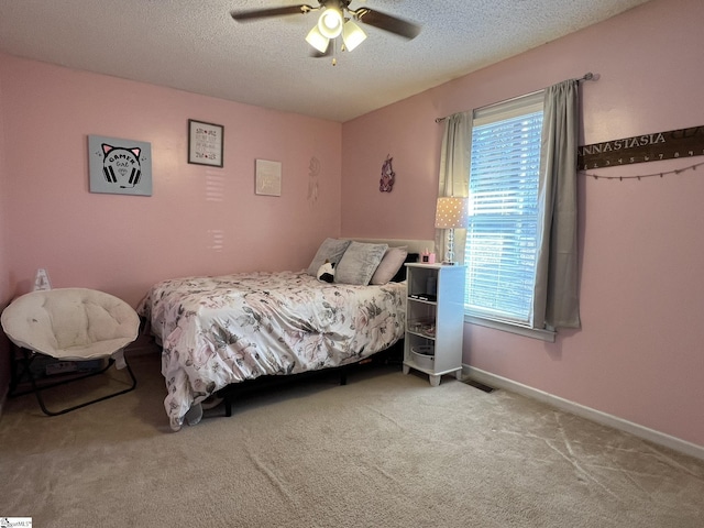 bedroom with light carpet, a textured ceiling, multiple windows, and ceiling fan