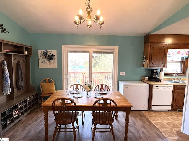 dining area featuring light hardwood / wood-style flooring, sink, vaulted ceiling, and a chandelier