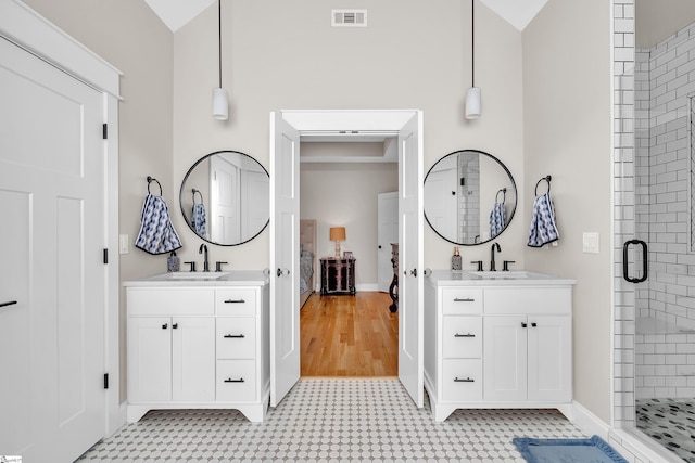 bathroom with an enclosed shower, vanity, and vaulted ceiling