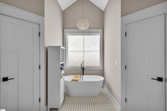 bathroom with a bath, a notable chandelier, and vaulted ceiling