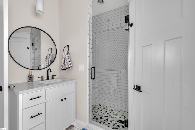 bathroom featuring a shower with door and vanity