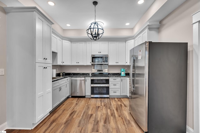 kitchen featuring light hardwood / wood-style flooring, an inviting chandelier, hanging light fixtures, stainless steel appliances, and white cabinets