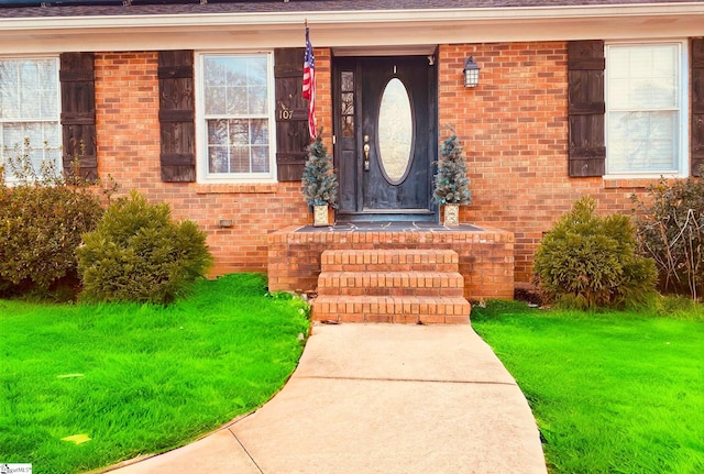 view of exterior entry featuring a yard