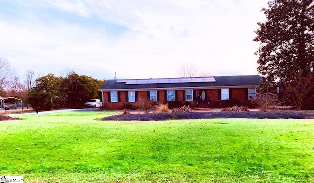 ranch-style home with a front lawn and solar panels