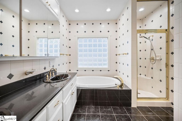 bathroom featuring vanity, independent shower and bath, and a wealth of natural light