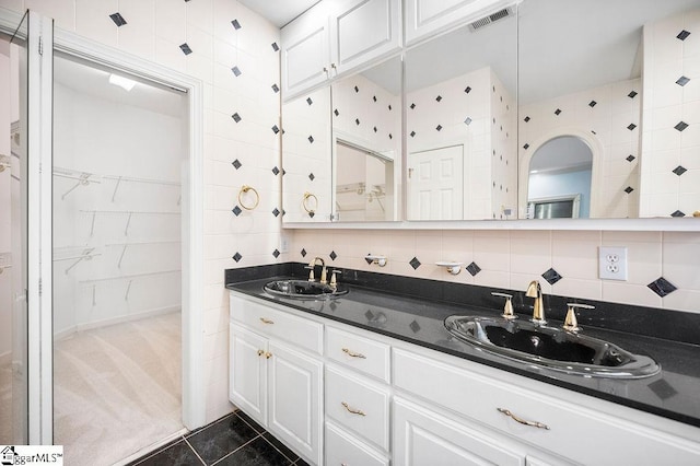 bathroom with tile patterned flooring, vanity, and decorative backsplash