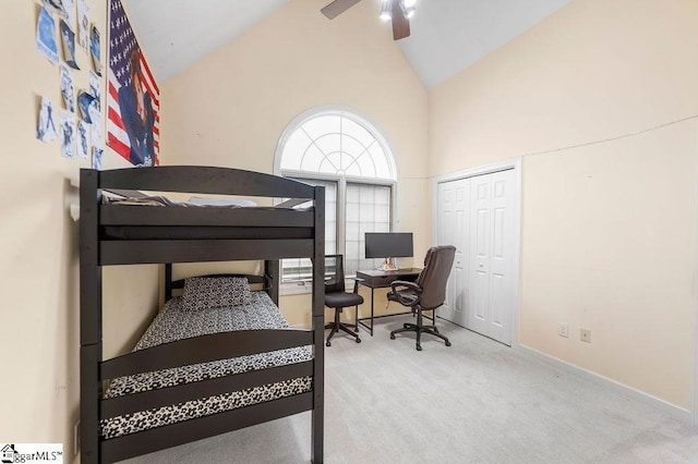 carpeted bedroom featuring ceiling fan, high vaulted ceiling, and a closet