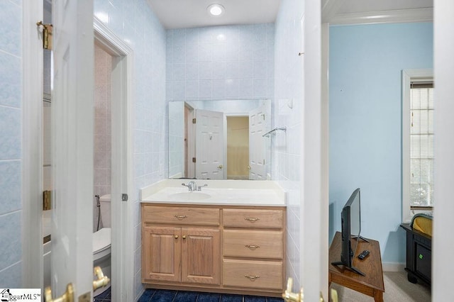 bathroom featuring ornamental molding, vanity, toilet, and tile walls