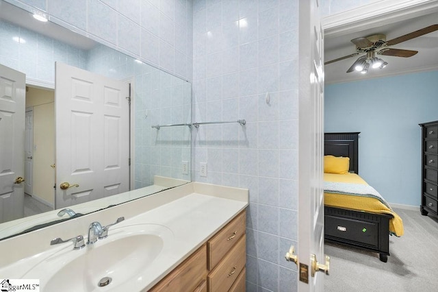 bathroom with vanity, tile walls, ceiling fan, and crown molding