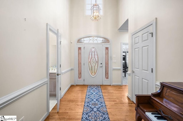 foyer with a high ceiling and light hardwood / wood-style flooring