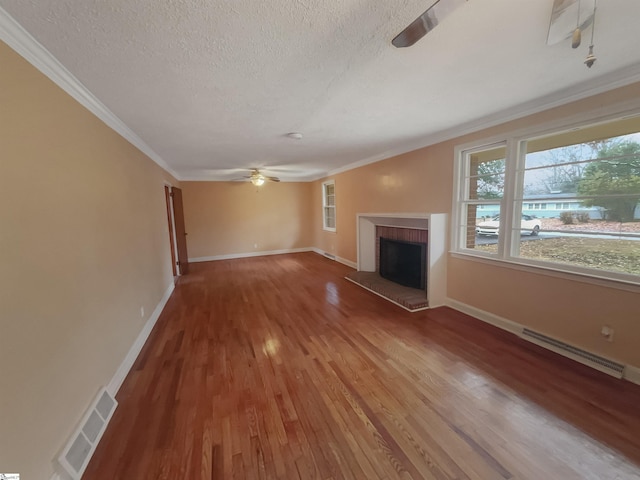 unfurnished living room with ceiling fan, wood-type flooring, a fireplace, and ornamental molding