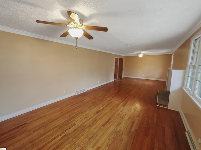 unfurnished room with crown molding, wood-type flooring, and a textured ceiling