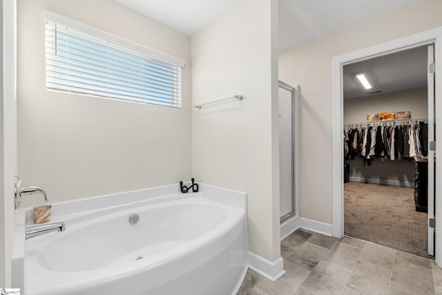 bathroom featuring shower with separate bathtub