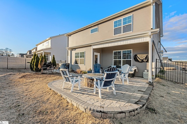 rear view of house with a patio and an outdoor fire pit