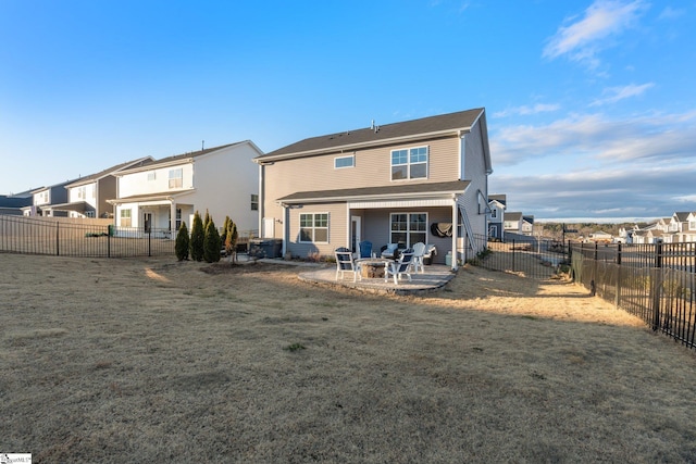 rear view of house featuring a patio, a fire pit, and a lawn