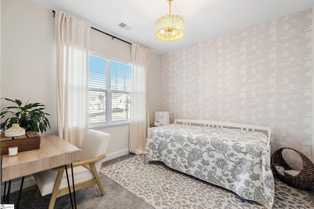 carpeted bedroom with an inviting chandelier