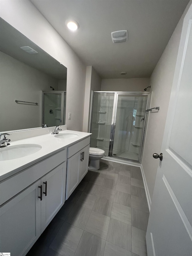 bathroom featuring vanity, toilet, and a shower with door