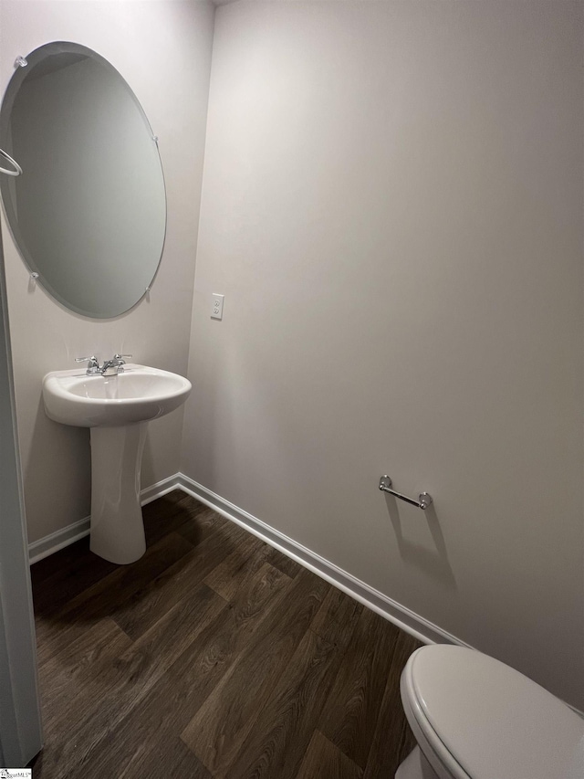 bathroom featuring wood-type flooring and toilet