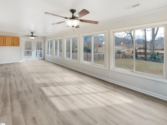 unfurnished sunroom with ceiling fan