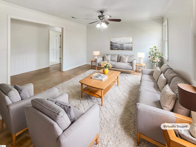 living room with hardwood / wood-style flooring, ornamental molding, and ceiling fan