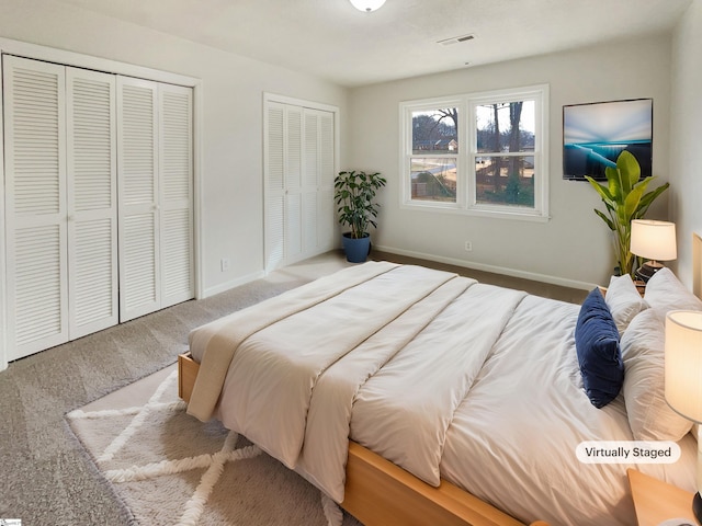 bedroom with multiple closets and carpet