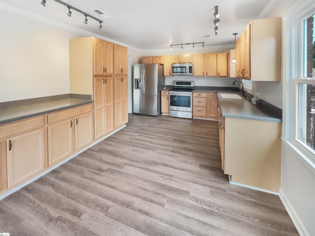 kitchen with light brown cabinetry, sink, stainless steel appliances, crown molding, and light wood-type flooring