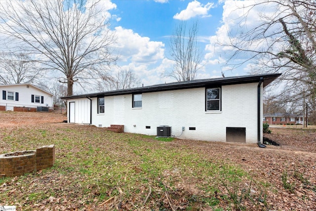 back of house with cooling unit and a yard