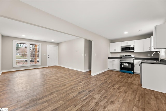 kitchen with stainless steel appliances, dark hardwood / wood-style flooring, sink, and white cabinets