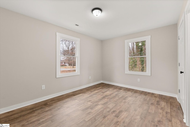 spare room with hardwood / wood-style flooring and a healthy amount of sunlight