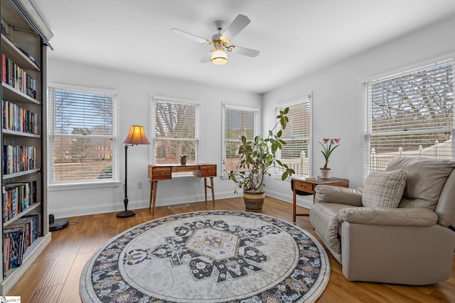 living area with hardwood / wood-style flooring and ceiling fan